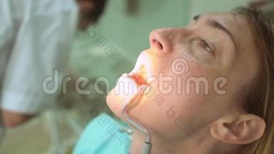 牙科门诊美女病人脸与牙医手的特写
